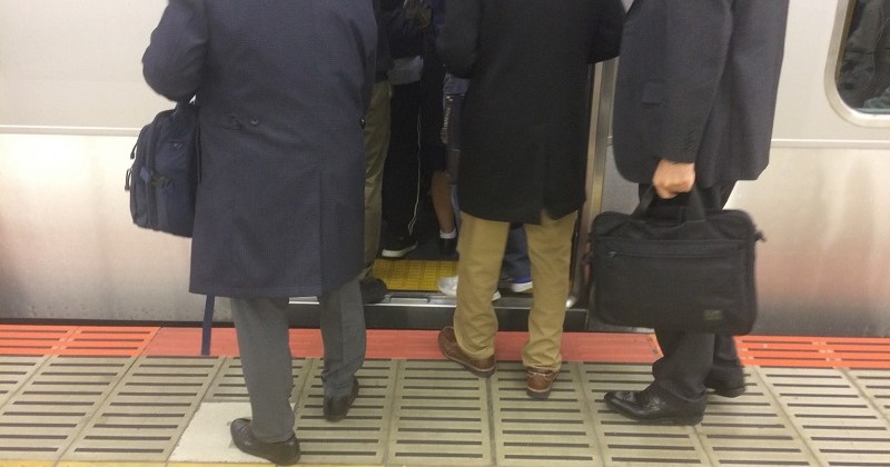 電車に乗るサラリーマン